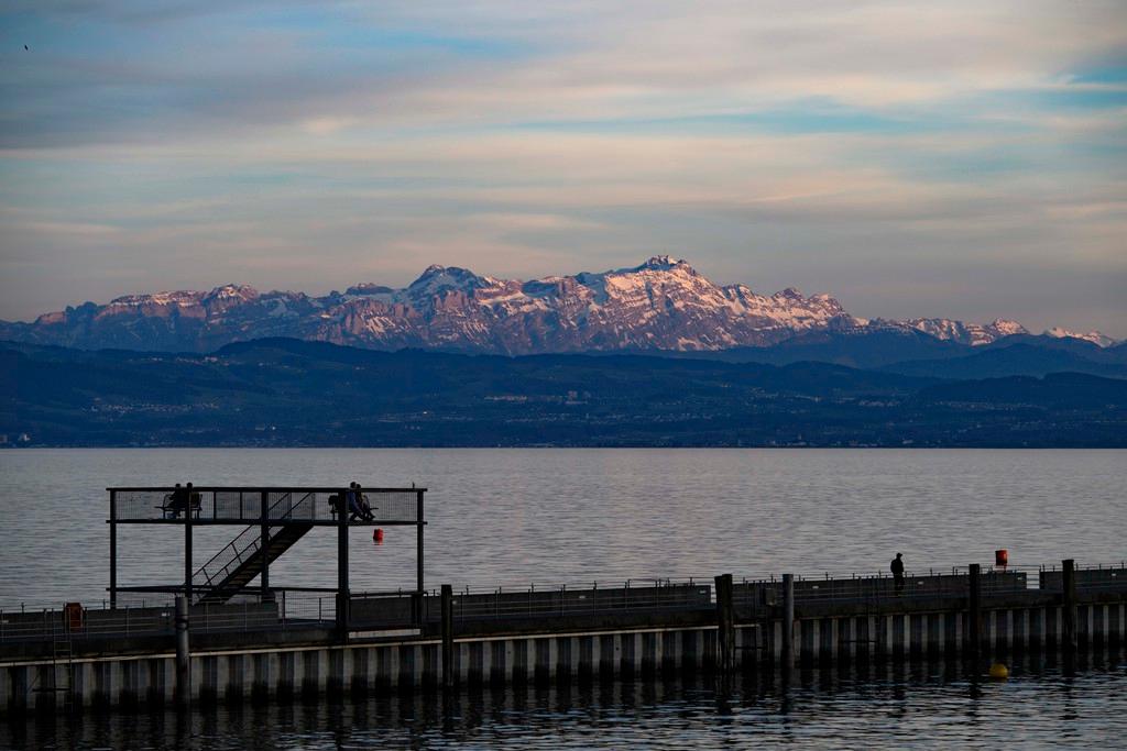 A view of Switzerland s Säntis mountain from Lake Constance, with a dock in the foreground