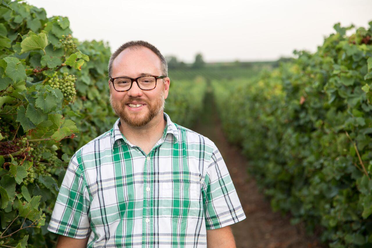 Portrait of Douglas J. Madenford standing in a vineyard