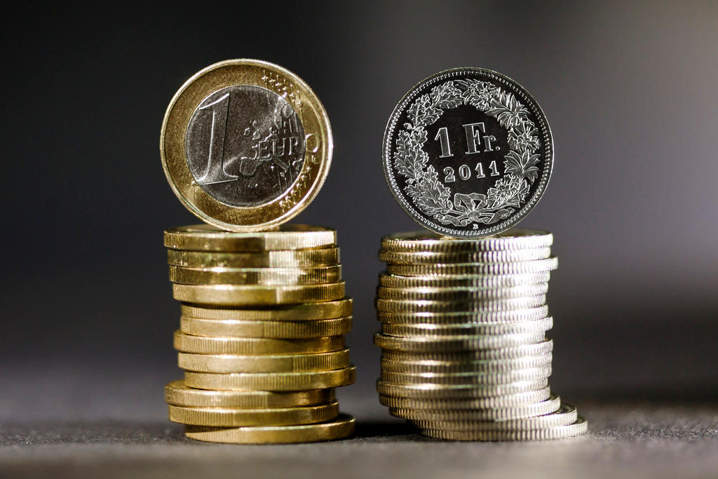 una pila di euro sulla sinistra e una pila di monete da un franco sulla destra