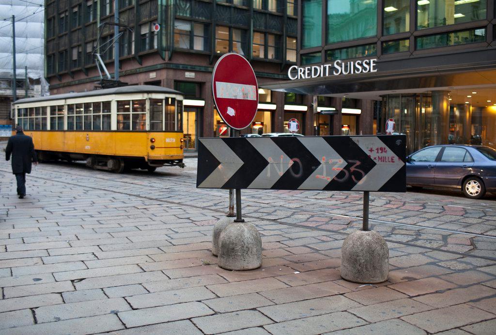 Un tram giallo transita davanti alla filiale di Milano del Credit Suisse.