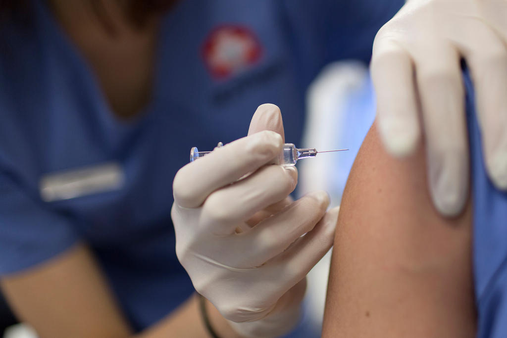 A medical assistant gives a flu vaccination at the Arzthaus in Zurich, Switzerland, on January 30, 2015.