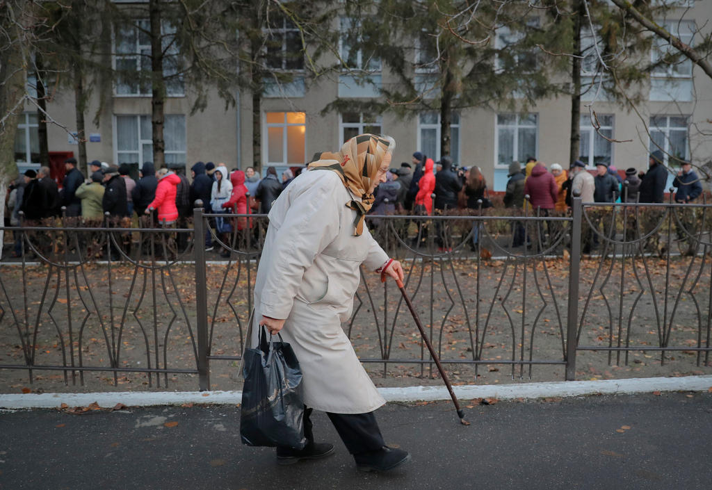 Uma senhora sai da cabine de votação na Moldávia