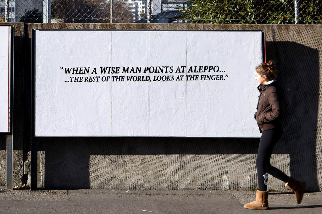 Manifesto con la scritta in inglese: Quando un uomo saggio prende la mira di Aleppo... il resto del mondo guarda il dito