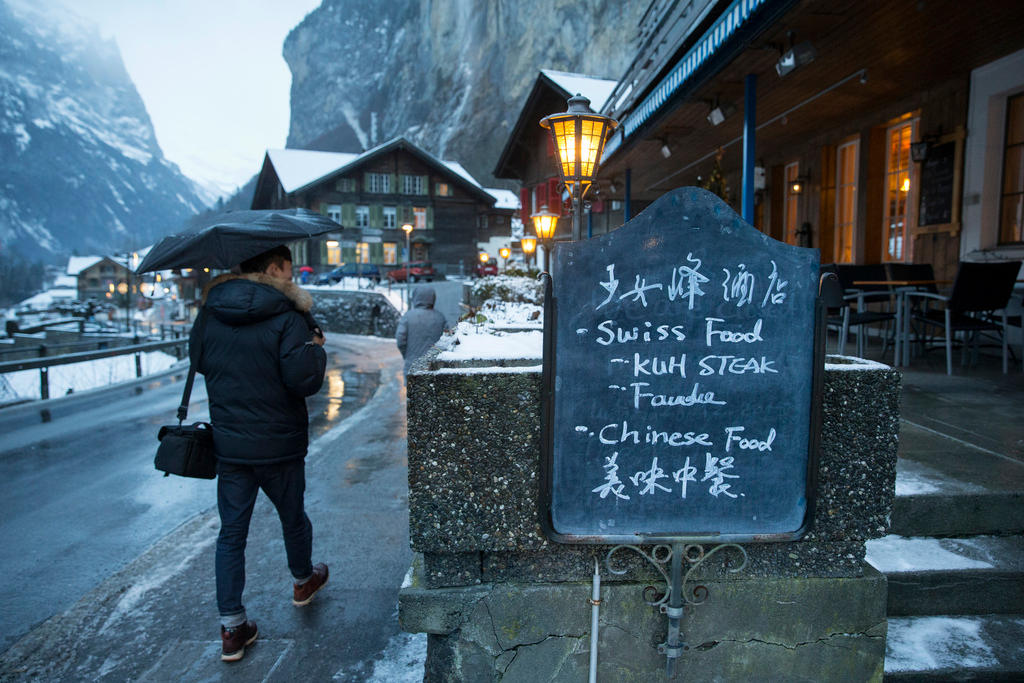A Chinese tourist walks through the Swiss mountain resort of Lauterbrunnen