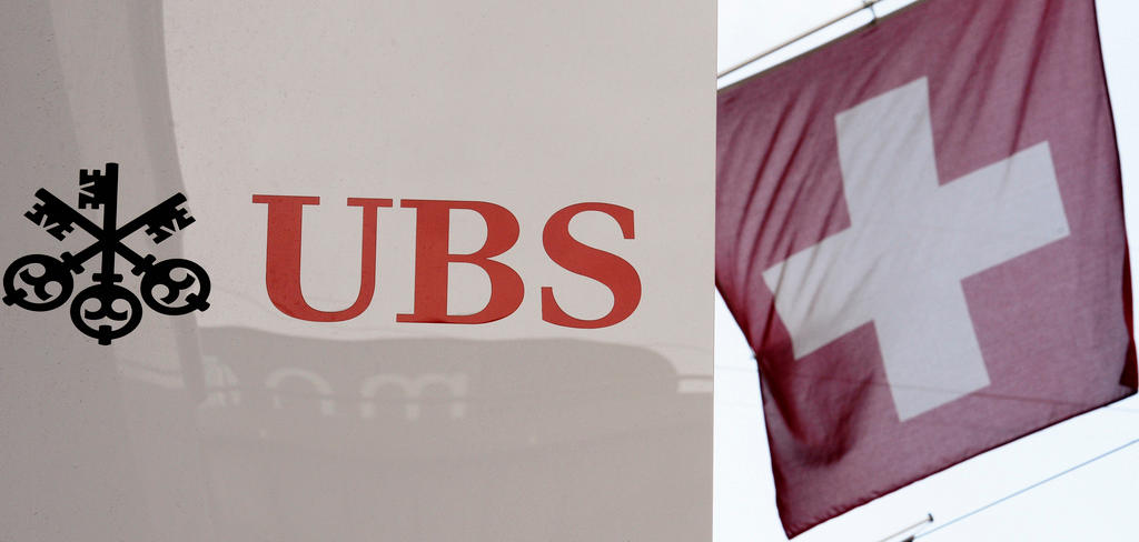 A sign displaying the UBS logo hangs next to a Swiss flag