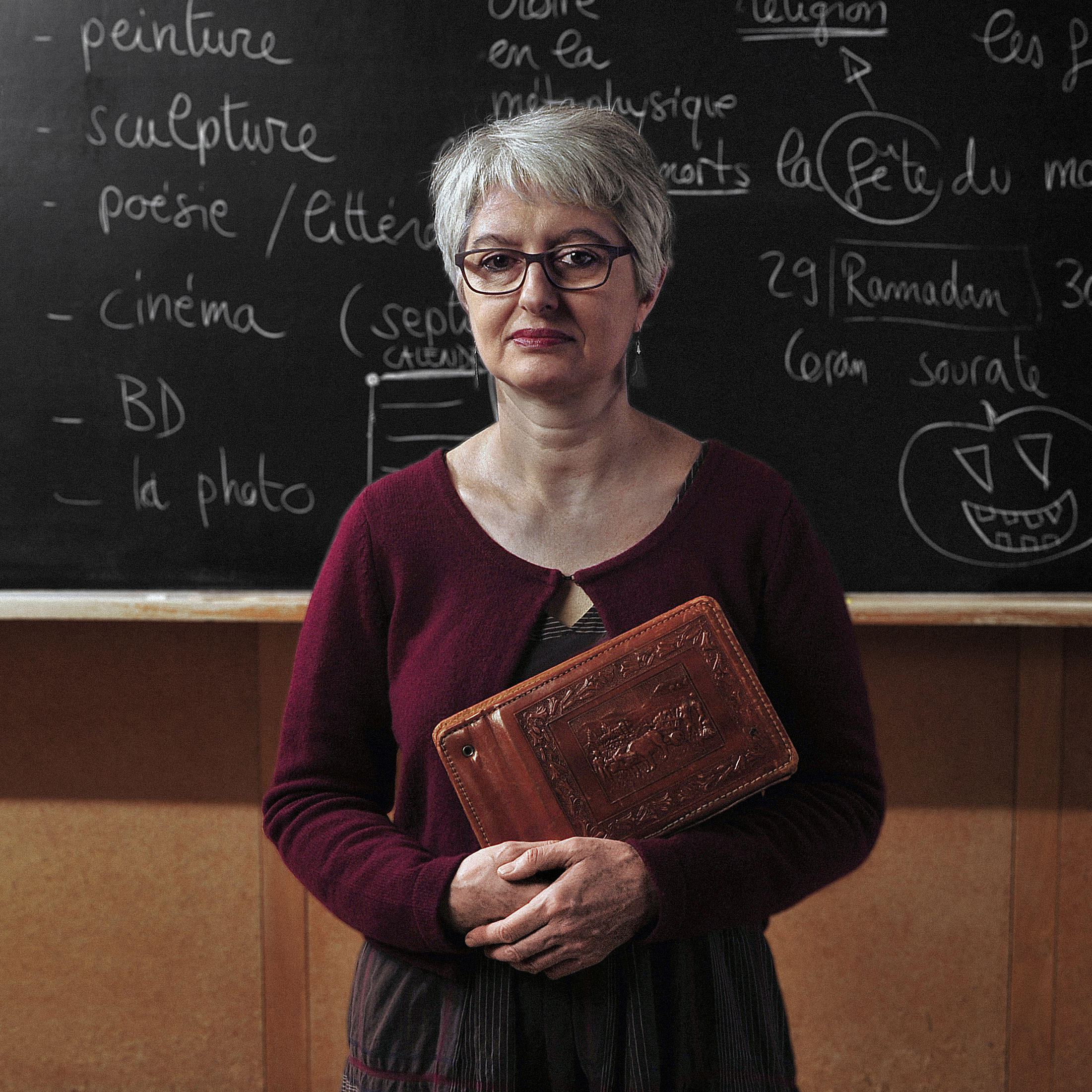 Woman holding book looks direct to the camera