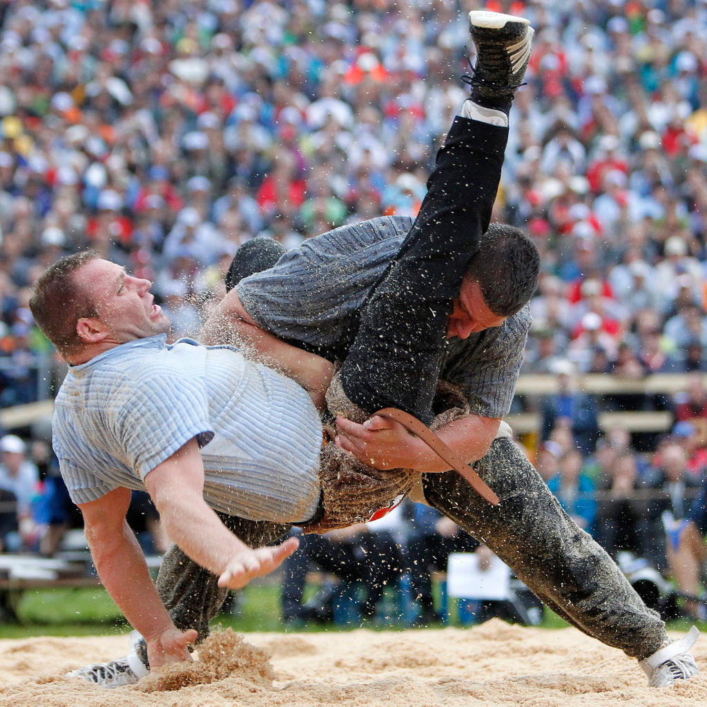 Two wrestlers in action in a sawdust pit