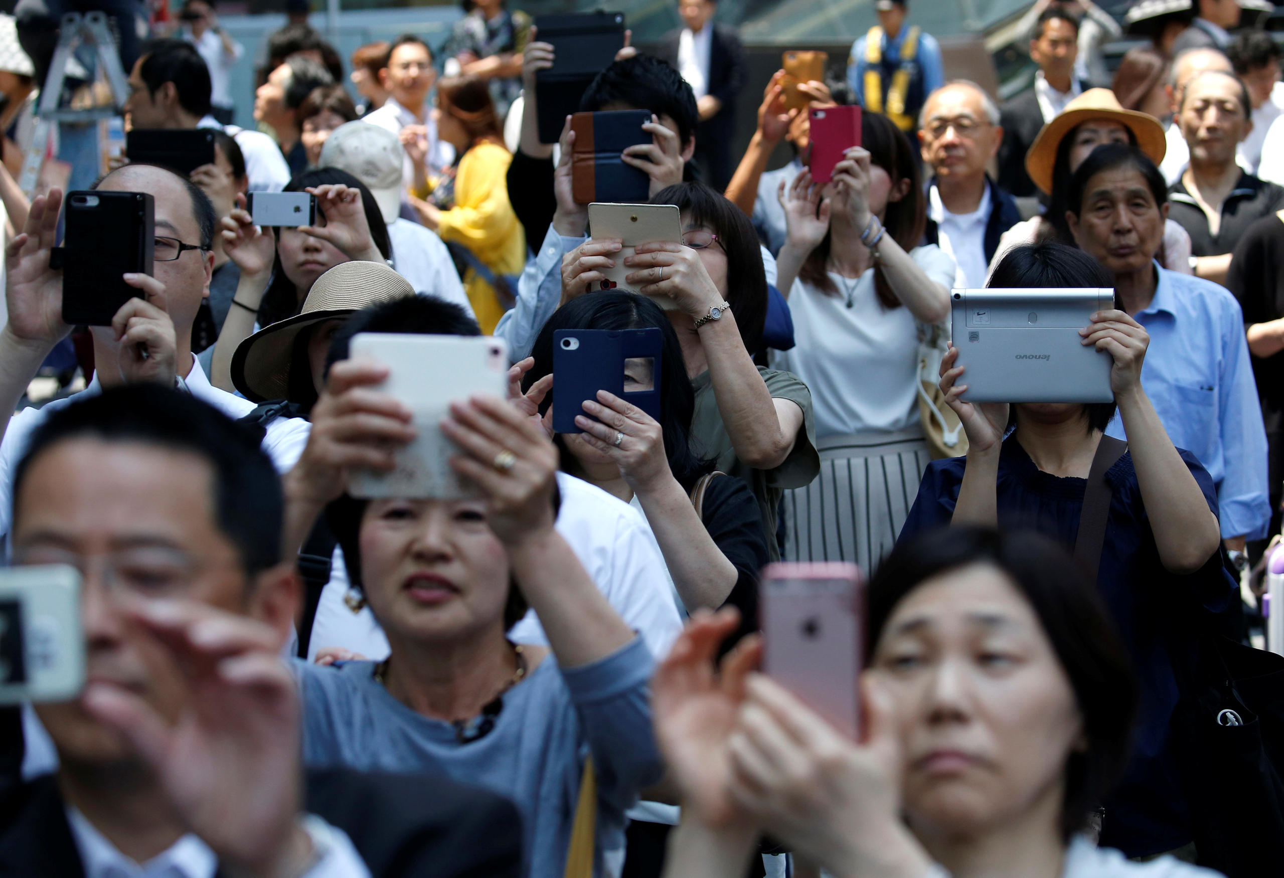 A Tokyo dei votanti scattano fotografie con lo smartphone a Yuriko Koike