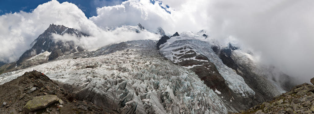 Aufnahme eines Gletschers, im Hintergrund Wolken und blauer Himmel.
