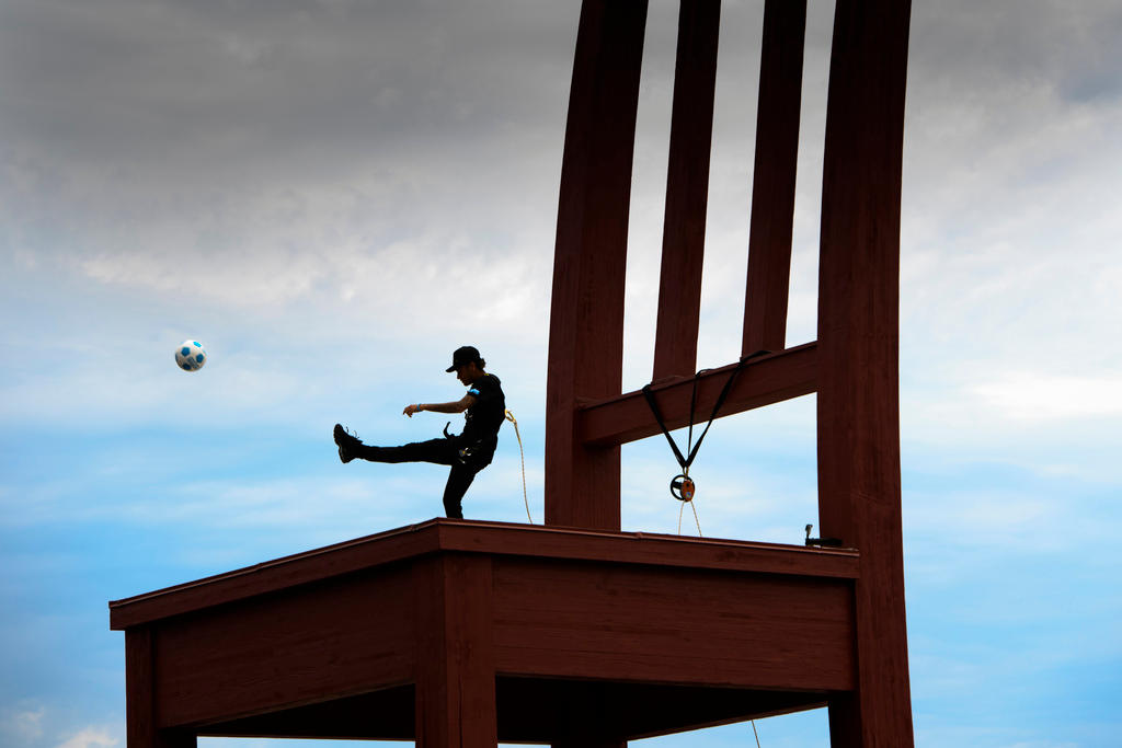 Brazilian star Neymar Jr juggles with a ball on the top of the Broken Chair landmine victim sculpture.