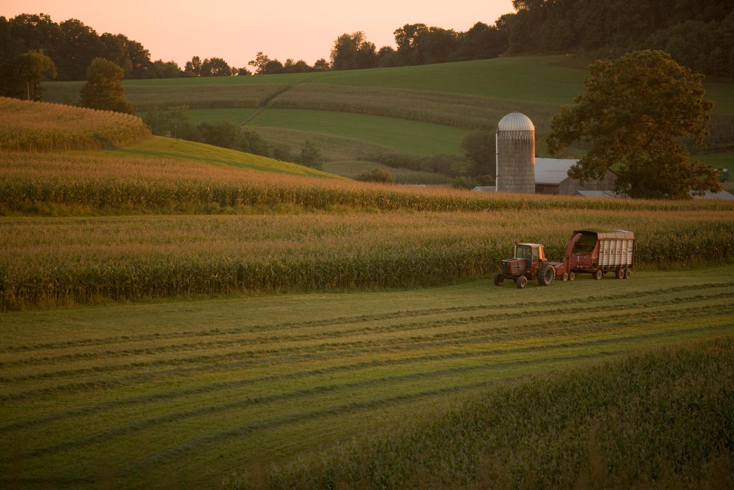 Um trator e o reboque em um campo de cultivo na Pensilvânia, Estados Unidos