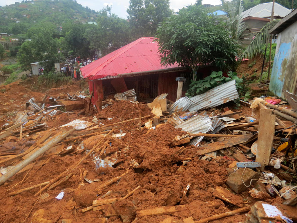 Volunteers search for bodies from heavy flooding and mudslides just outside of Sierra Leone s capital Freetown