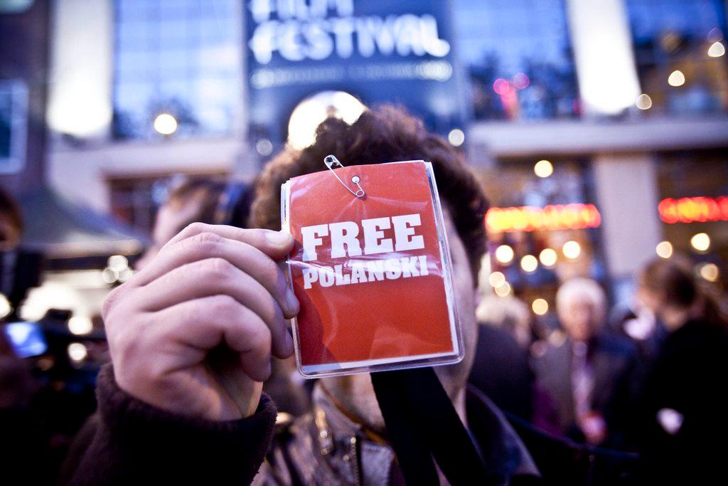 Ein Mann hält eine Karte mit der Aufschrift Free Polanski