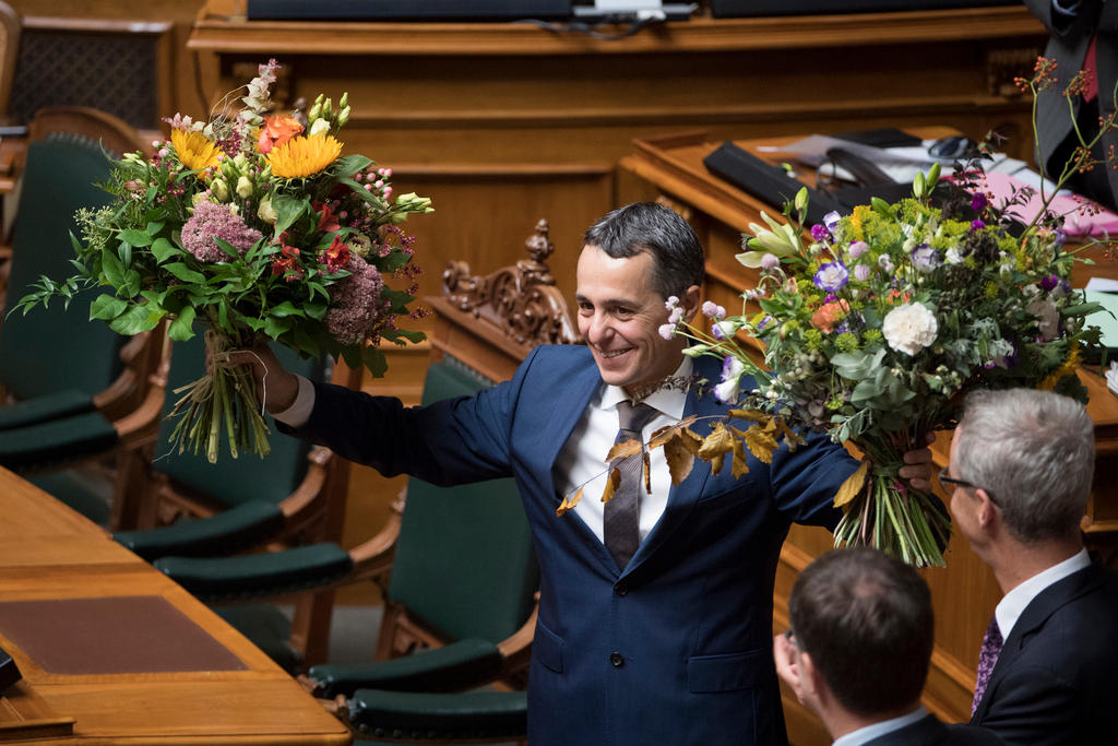 Ein Mann hält zwei Blumensträusse