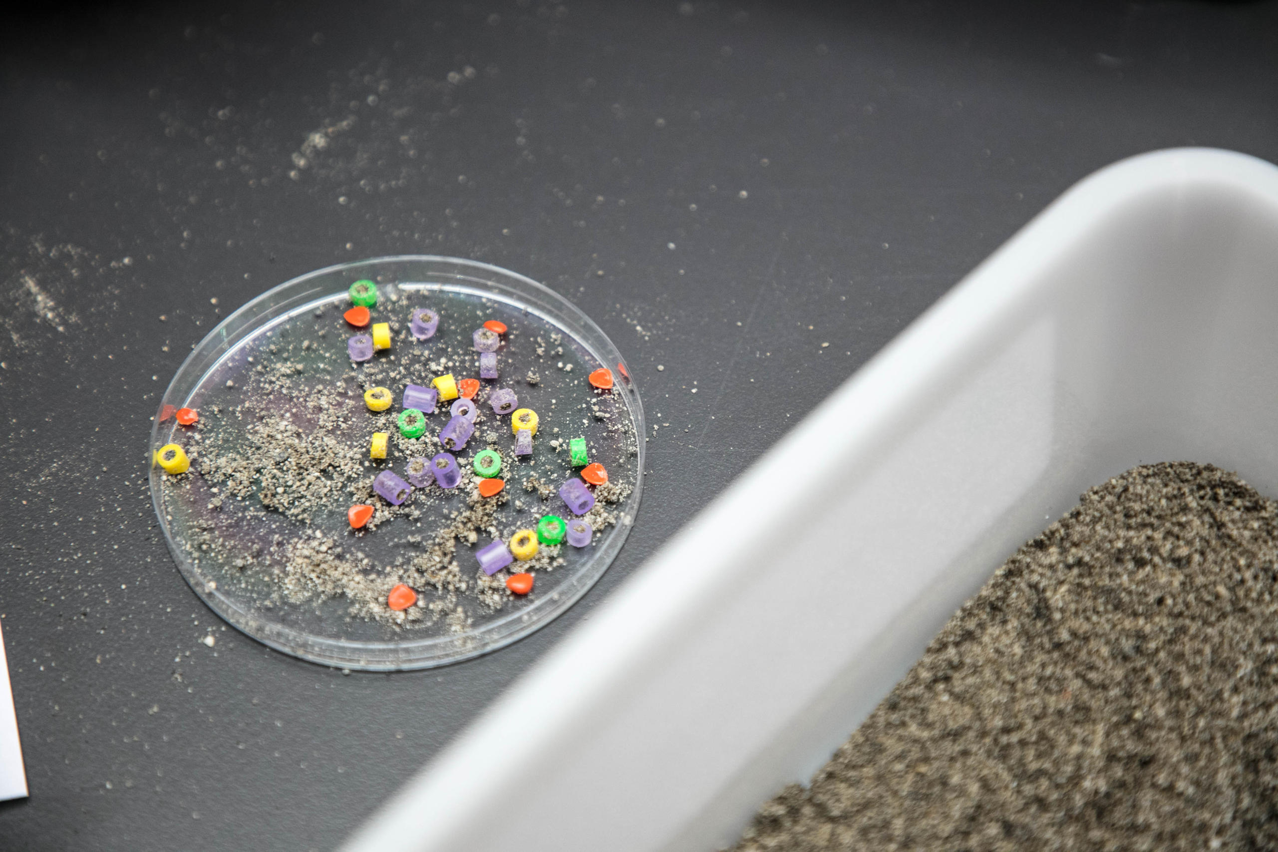 Petits bouts de plastiques dans du sable.