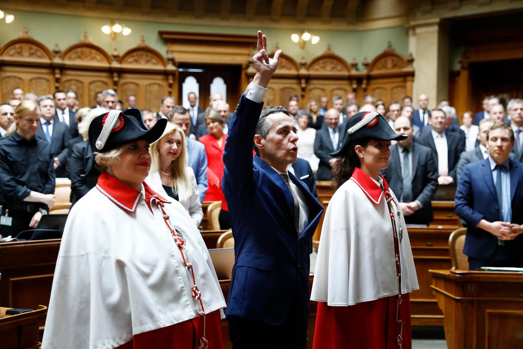 Le Tessinois Ignazio Cassis prête serment en italien, en levant trois doigts de sa main droite.