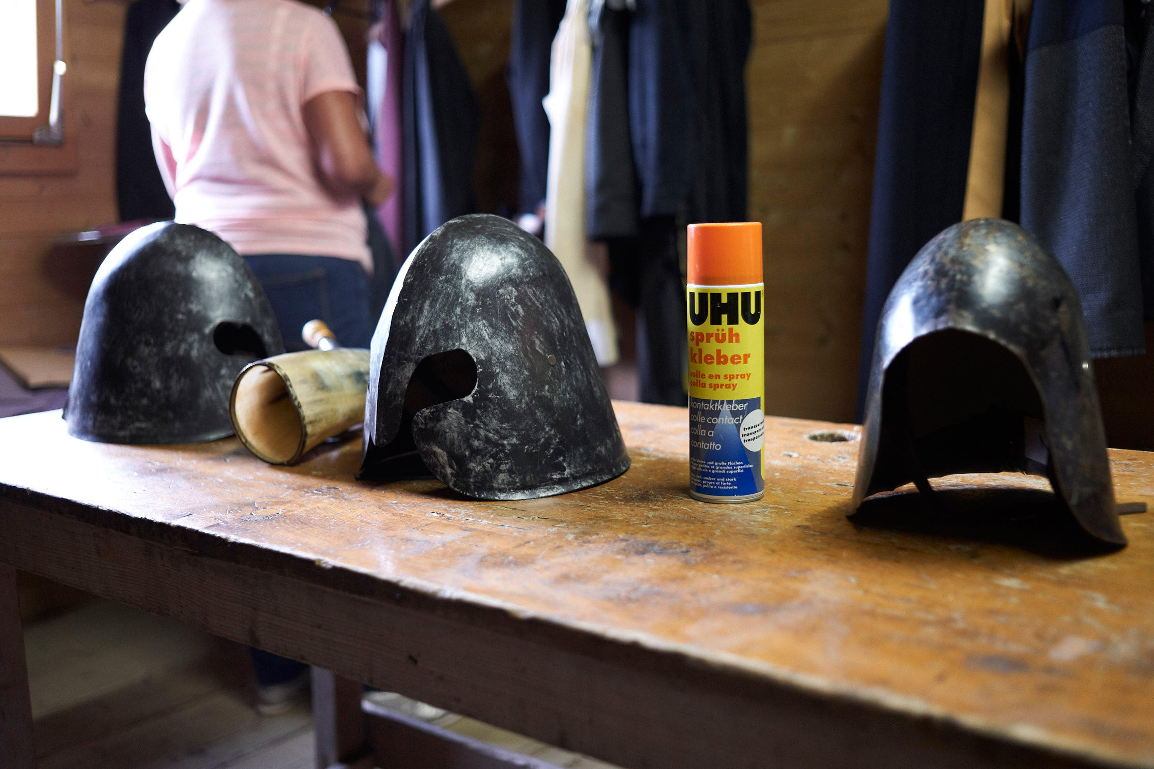 Knight s helmets on a table with a can of glue