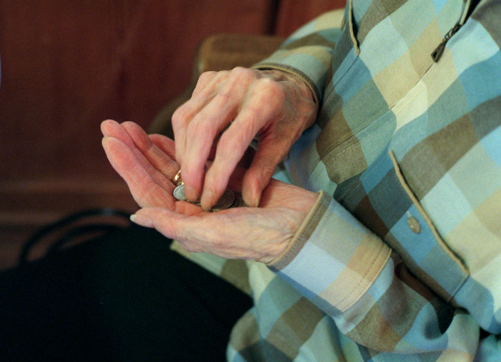 Old hands holding coins