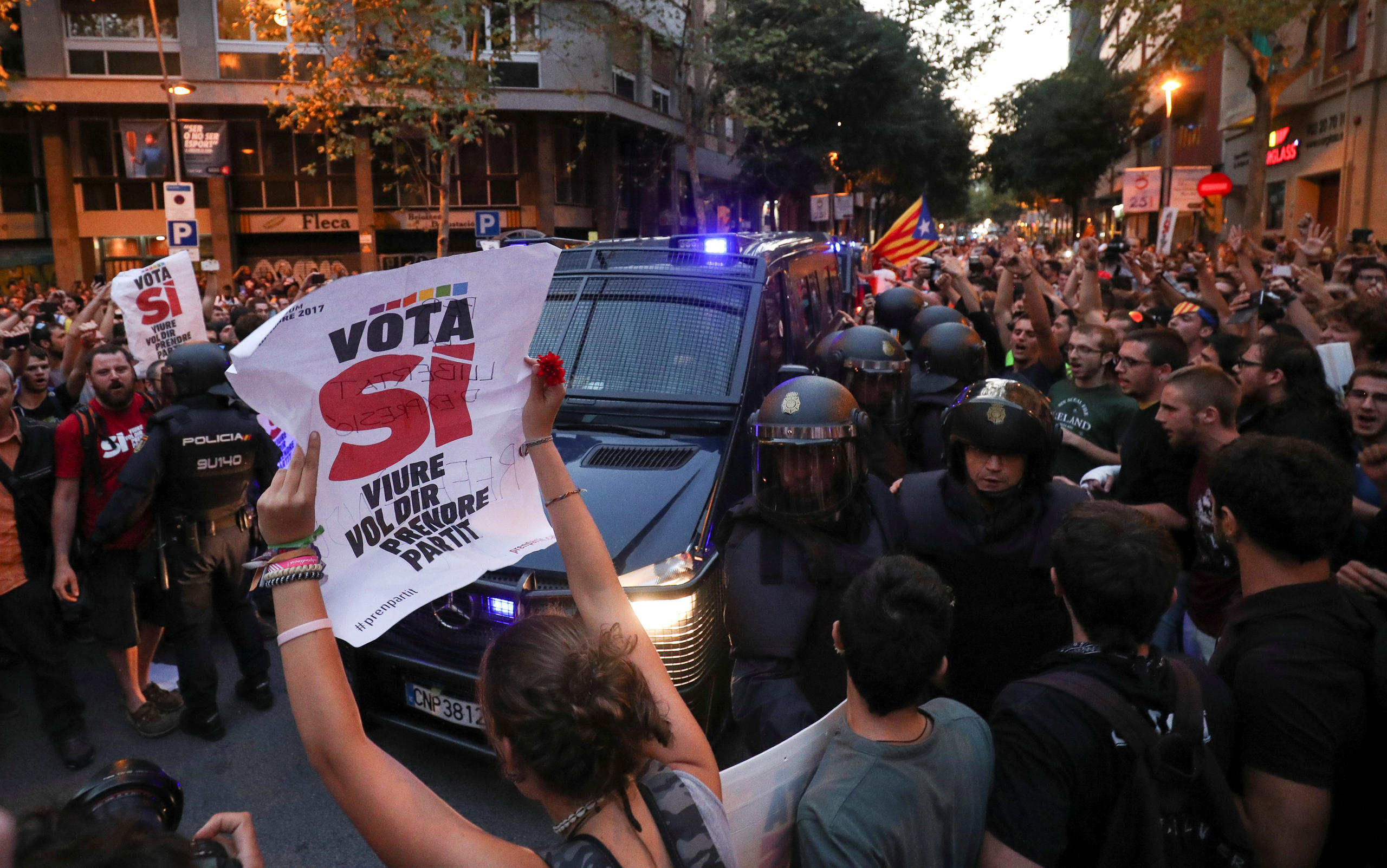 Un vehículo policial pasa en medio de manidestación separatista en Barcelona.