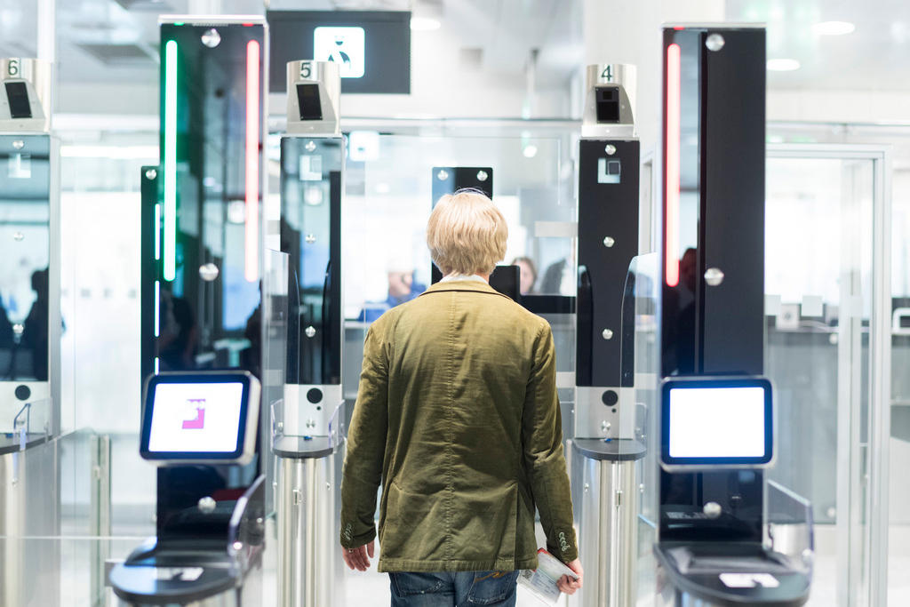 A man in a brown jacket scans his face