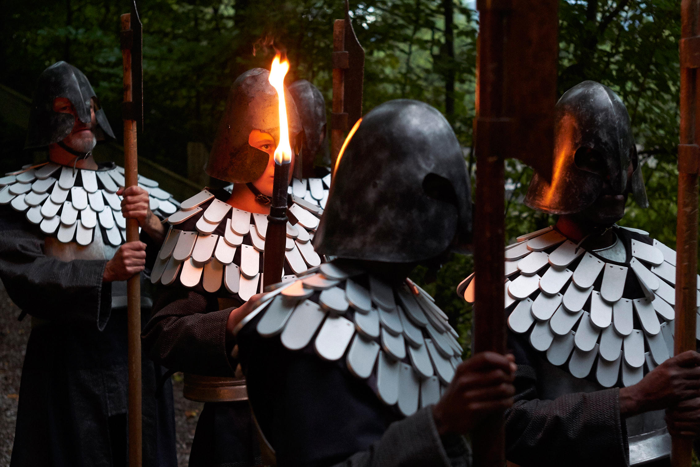 Actors dressed as soldiers bearing flaming torches