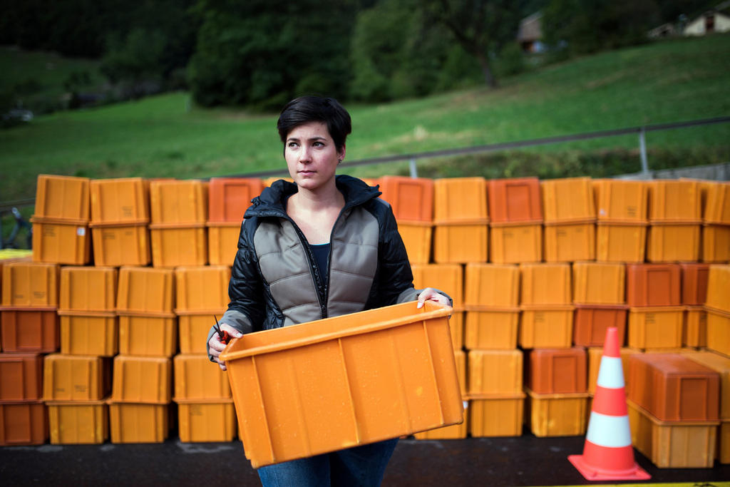 Una ragazza tiene in mano una scatola di plastica che userà per raccogliere l uva.