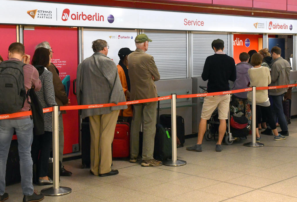 صف طويل من المسافرين ينتظرون دورهم أمام مكتب تابع لشركة إر برلين في مطار تيغل بالعاصمة الألمانية