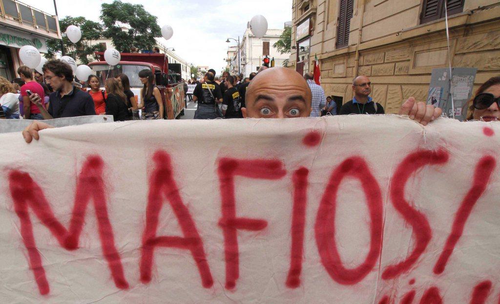 striscione con la scritta mafiosi esposto durante una manifestazione a Reggio Calabria