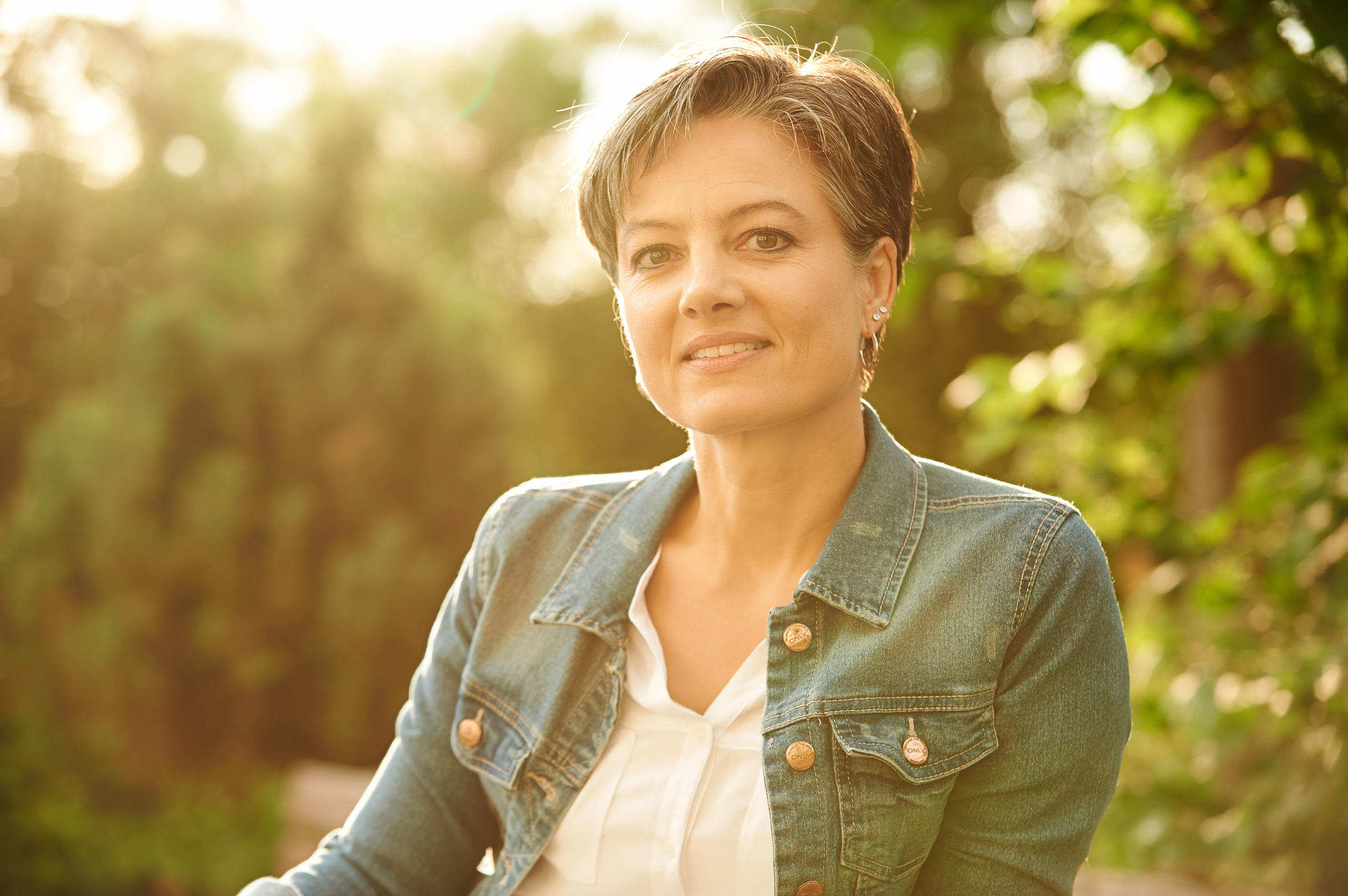 Eine gepflegte Frau blickt lächelnd in die Kamera