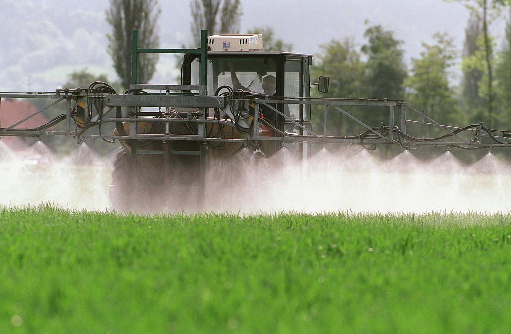 Farmer sprays field with pesticides in spring