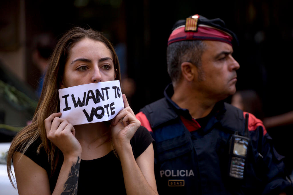 Una giovane dona catalana esibisce un foglio con la scritta voglio votare. Tensione a Barcellona