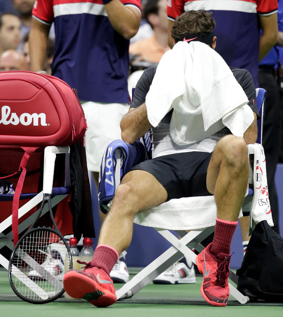 Roger Federer sentado durante pausa na partida