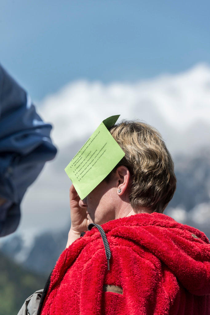 Woman hols ballot paper on face