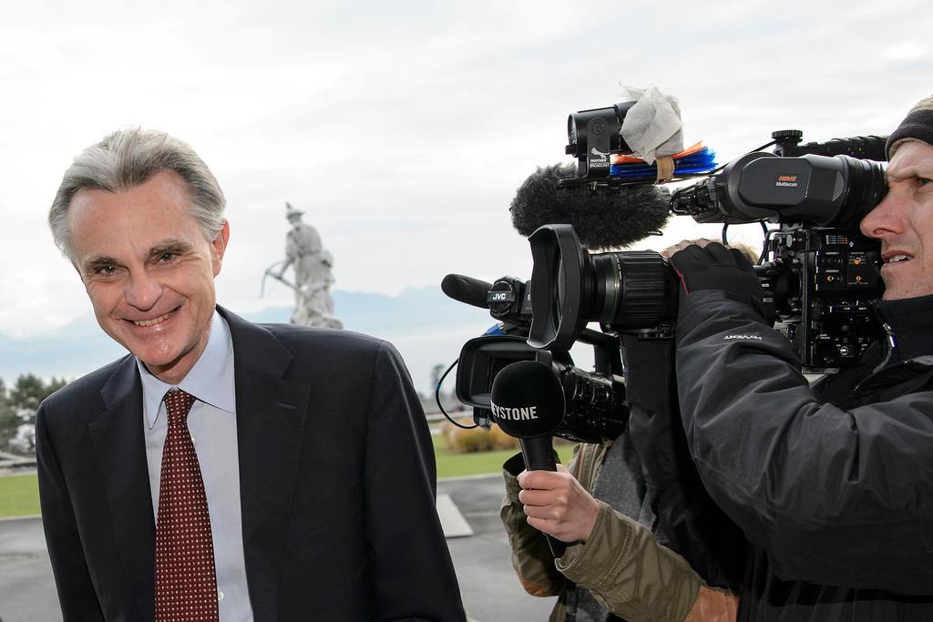 A smiling Jean-Marc Duvoisin being filmed by a camera crew