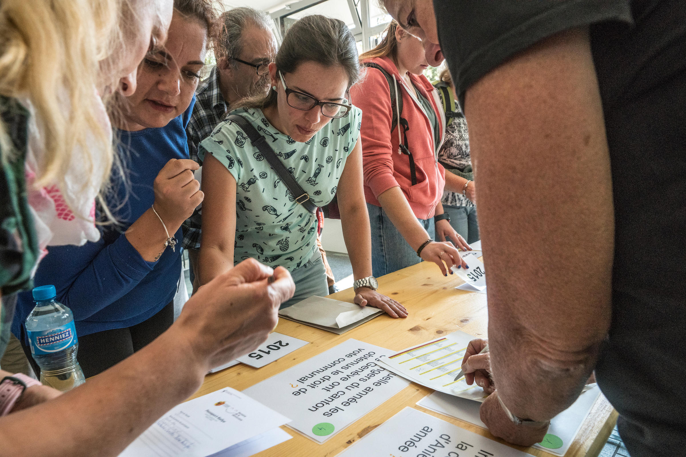 Un gruppo di persone che leggono dei fogli su un tavolo e si consultano.