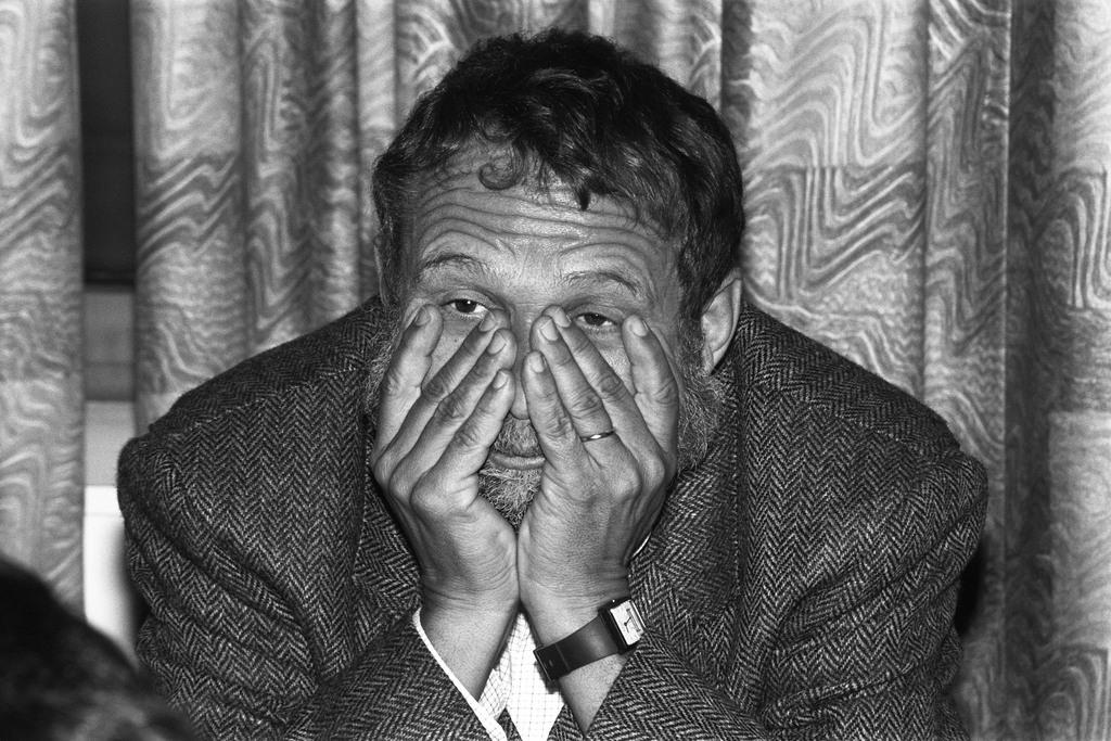 Ein Mann stützt den Kopf in die Hände