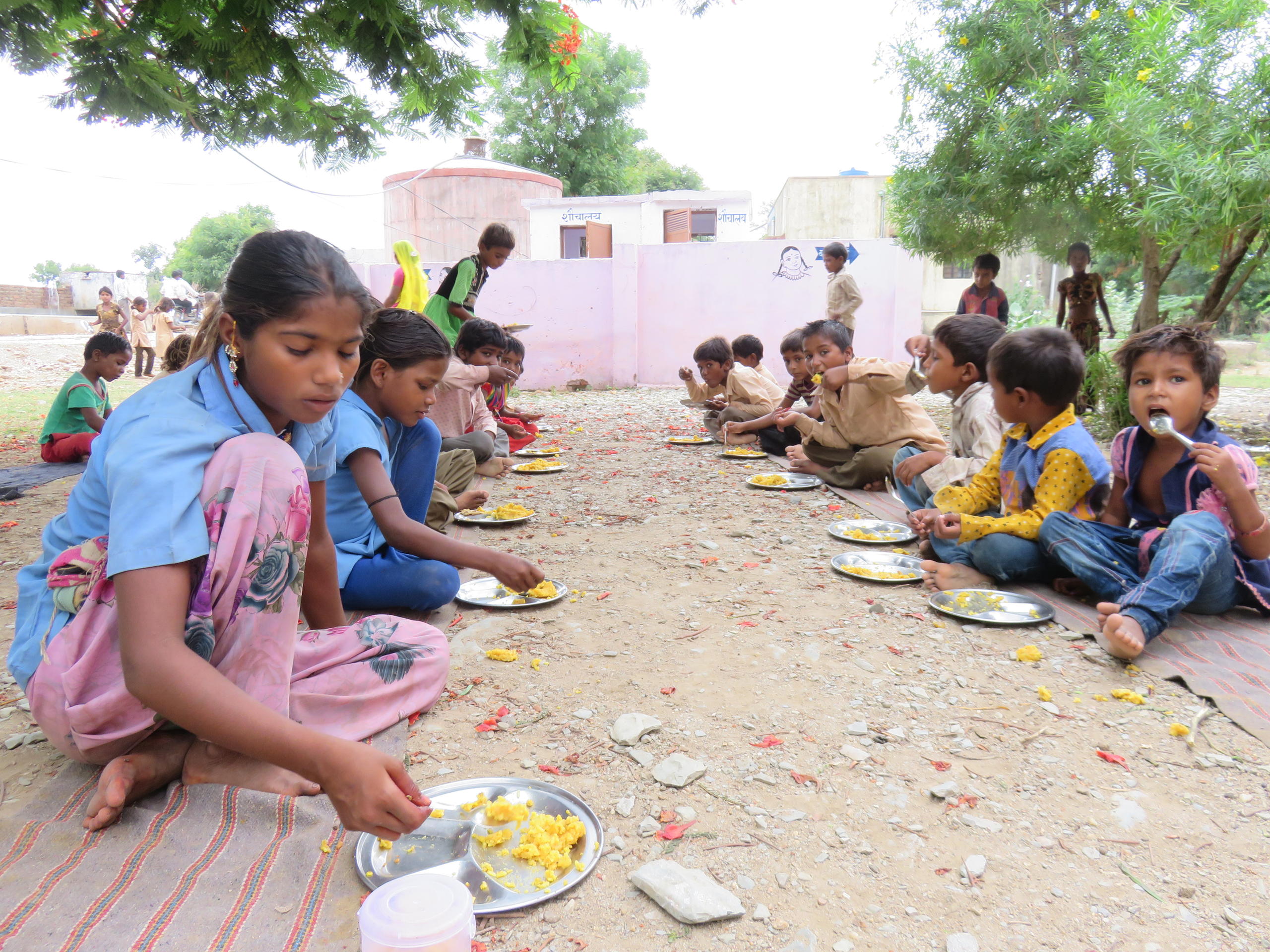 children eating lunch outside school