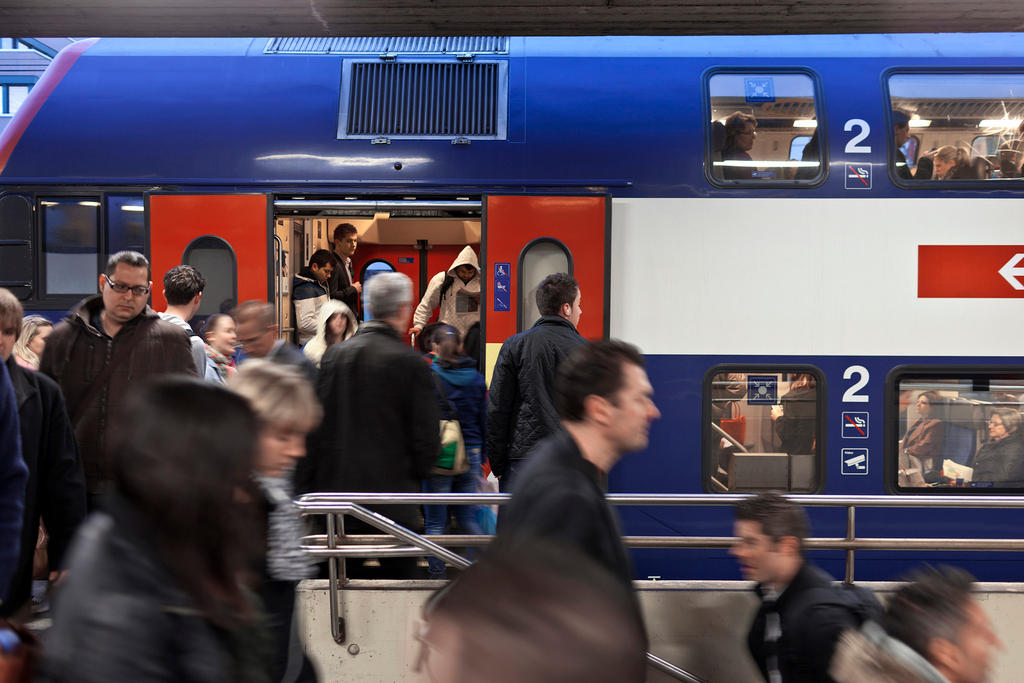 Commuters board train at Swiss station