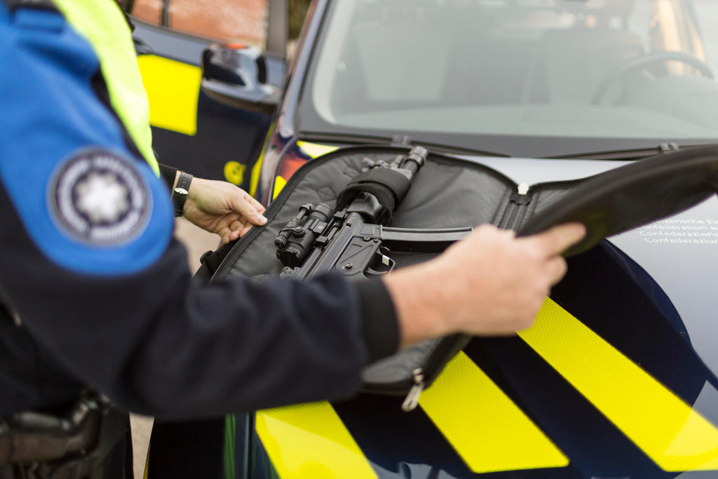 Una guardia di confine prepara la sua arma prima di un controllo