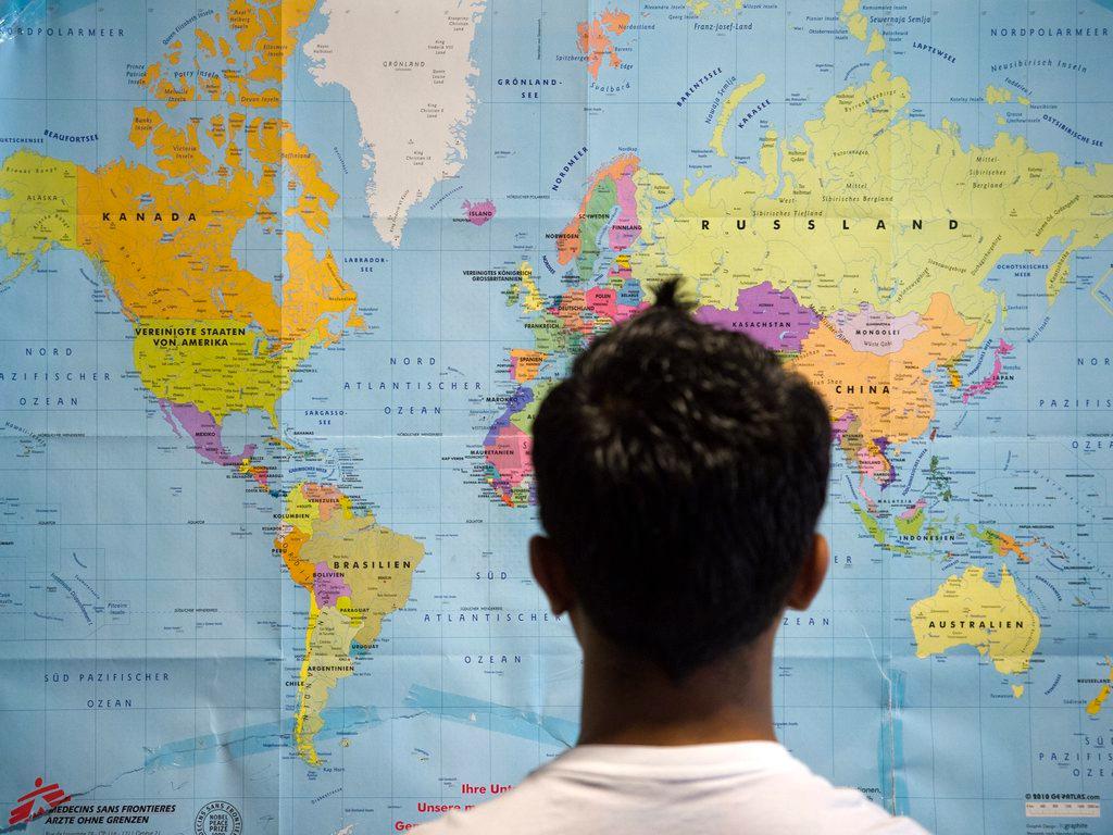 Asylum seeker in front of a map