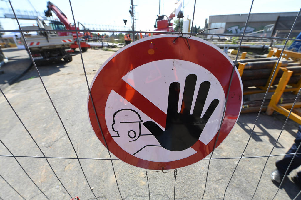 A stop sign on a gate in front of a building site
