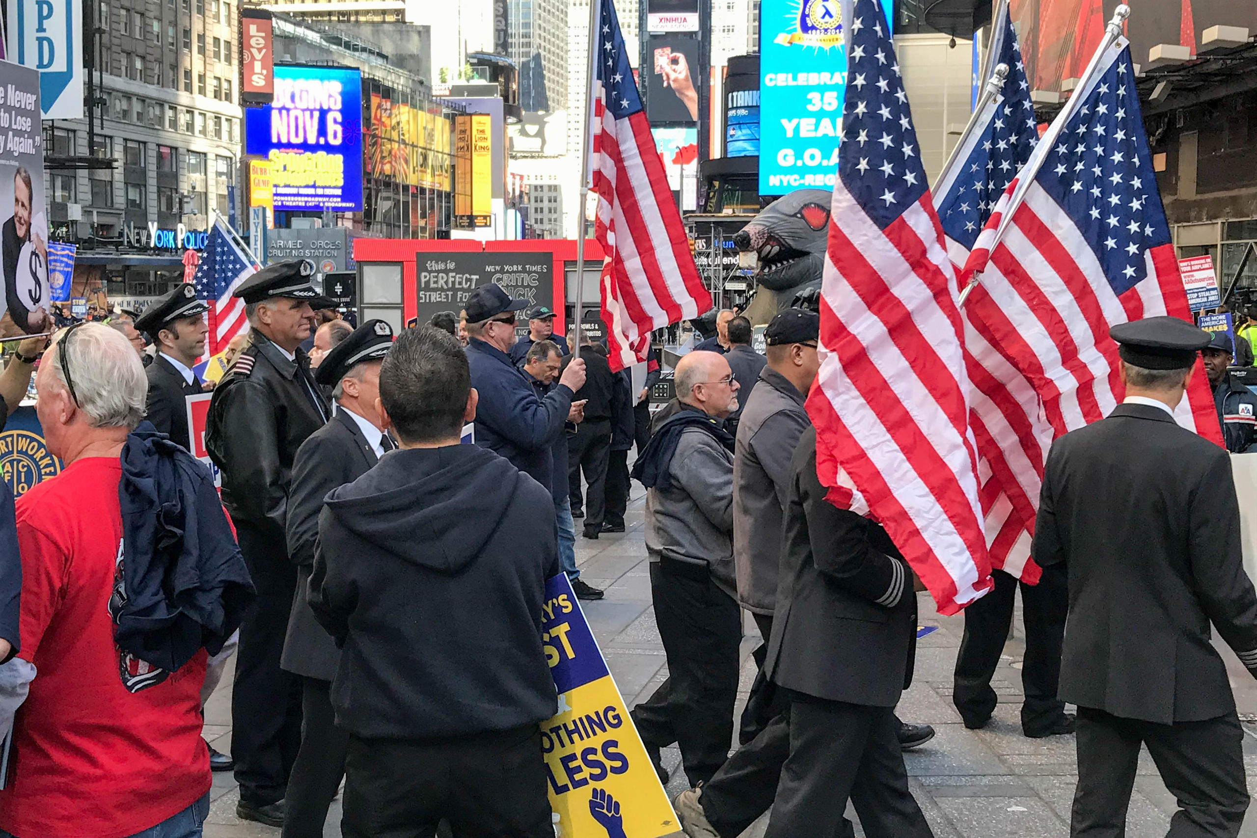 People in uniform carrying the American flag in the streets