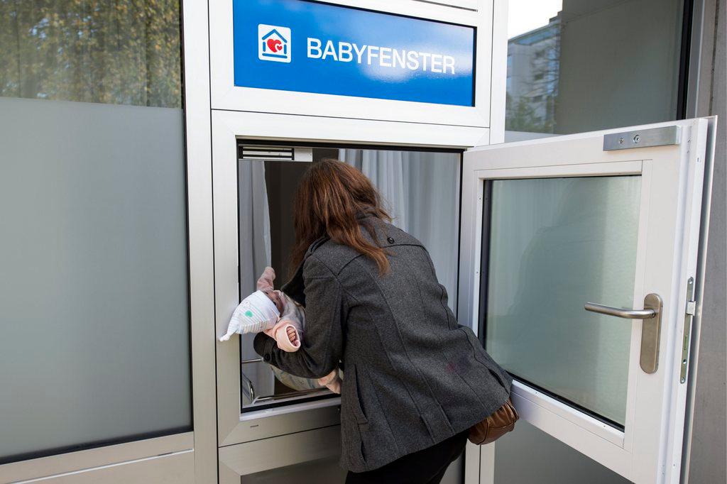 mother leaving infant in a baby box