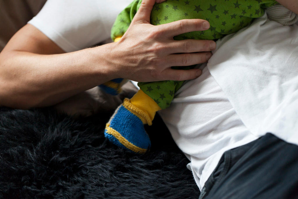 A father is holding his newborn child in his arms.