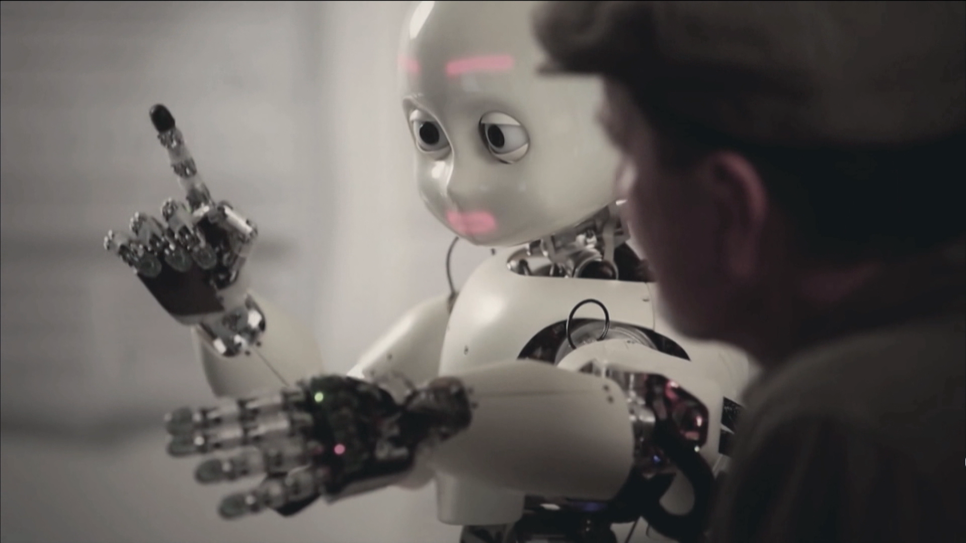 Il co-direttore dell IDSIA Jürgen Schmidhuber (di spalle) interagisce con un robot iCub.