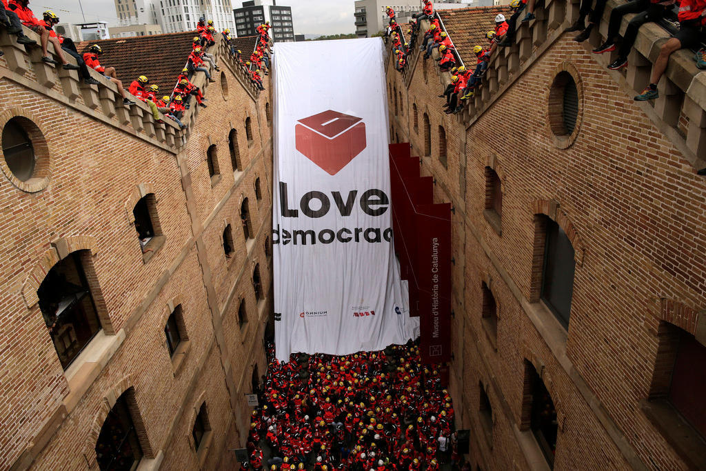 fire-fighters raise a banner in favour of the Catalonian referendum