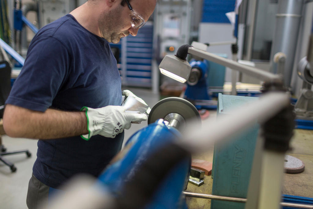 An employee of MAN Diesel & Turbo Switzerland grinds turbine blades of a turbo compressor in Zurich.