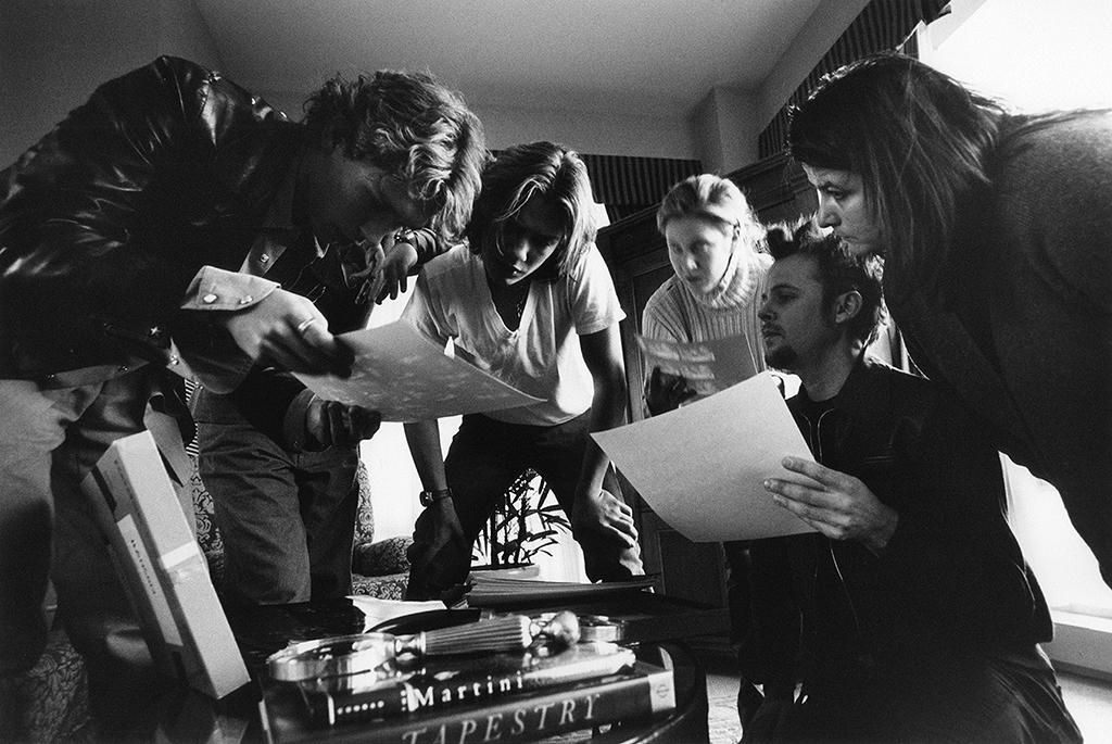 five people looking downat sheets of peper