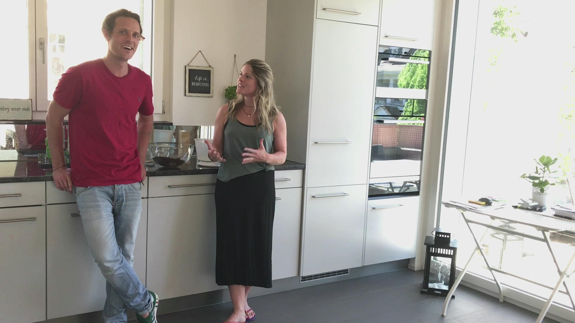 A brother and sister standing in a kitchen