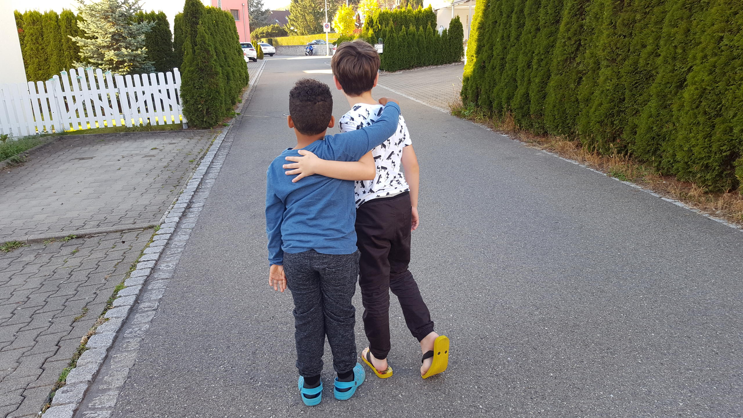 Duas crianças se abraçando em uma rua